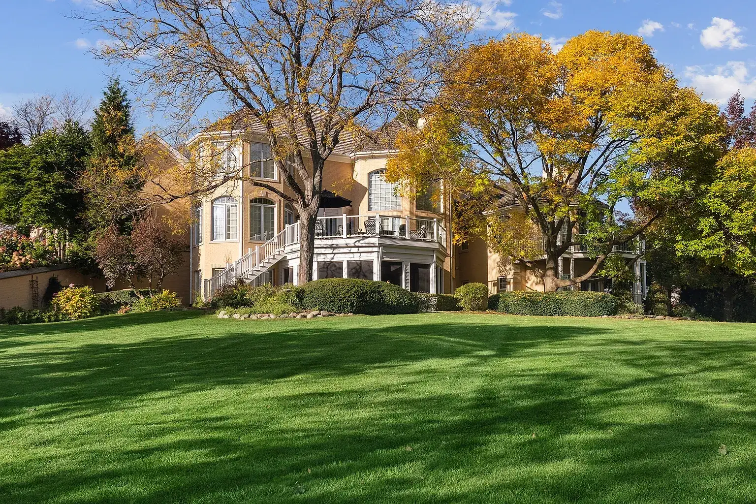 Back of the house with a curved staircase and decks above the lawn