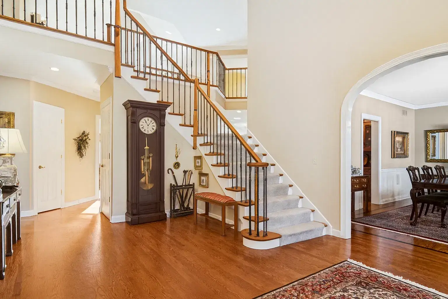 Two-story foyer with a curved staircase and hardwood floors