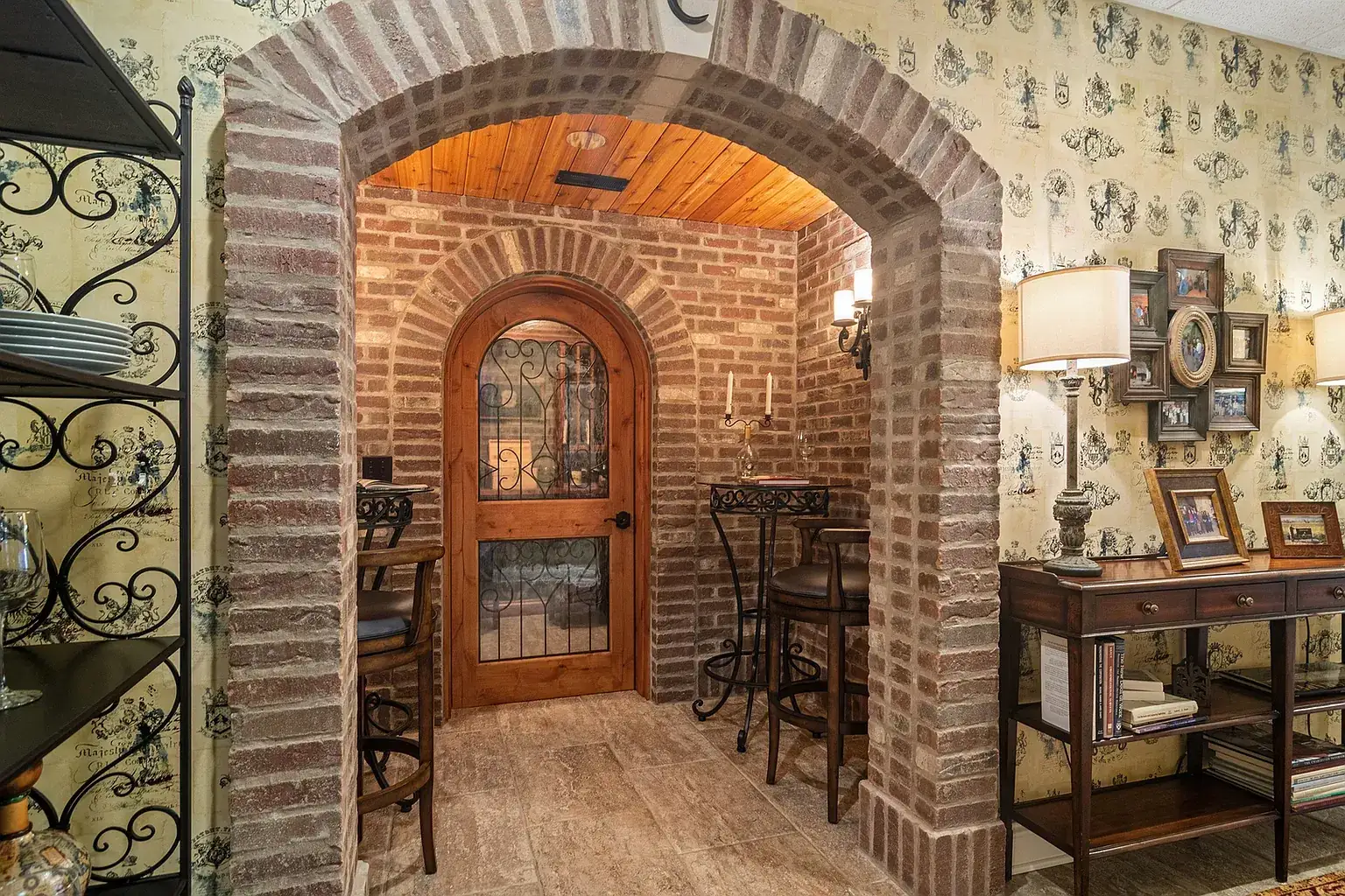 Brick archway leading to an arched wooden wine cellar door