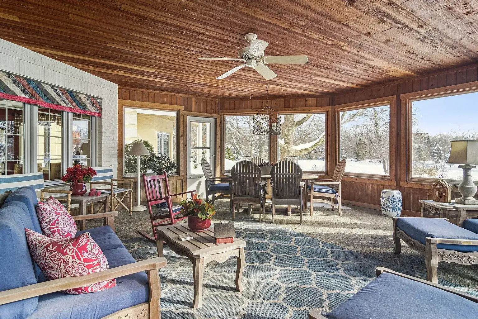 Screened porch with a wood ceiling and windows onto the yard
